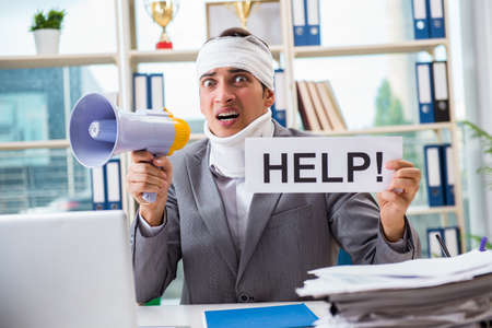 Injured businessman working in the officeの写真素材