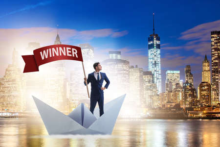 Businessman riding paper boat ship in winning conceptの写真素材
