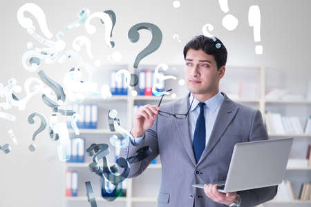 Businessman in uncertainty concept with many unanswered questionの写真素材