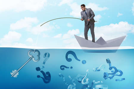 Businessman fishing questions from paper boat shipの写真素材