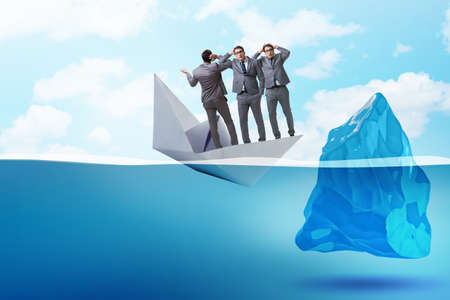 Economic crisis concept with businessman in sinking paper boatの写真素材
