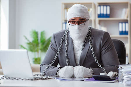 Bandaged businessman worker working in the office doing paperworの写真素材
