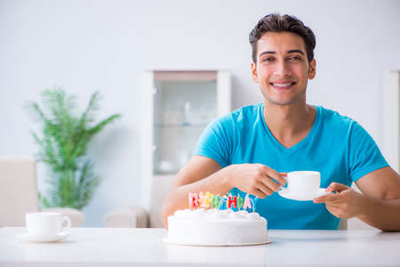 Young man celebrating birthday alone at homeの写真素材