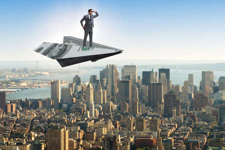 Businessman flying on paper plane in business conceptの写真素材