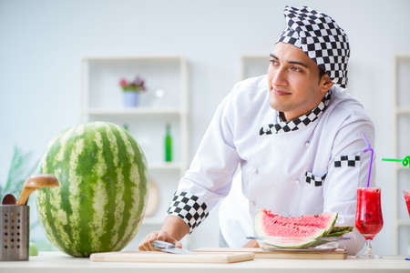 Male cook with watermelon in kitchenの写真素材
