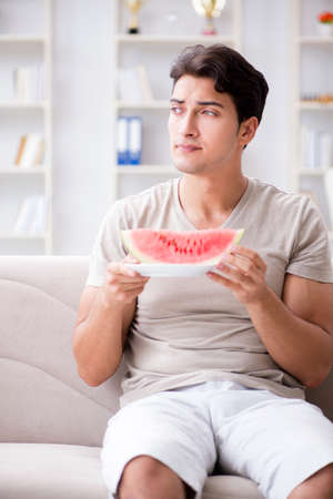Man eating watermelon at homeの写真素材