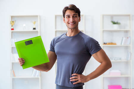 Man with scales in sports and health conceptの写真素材