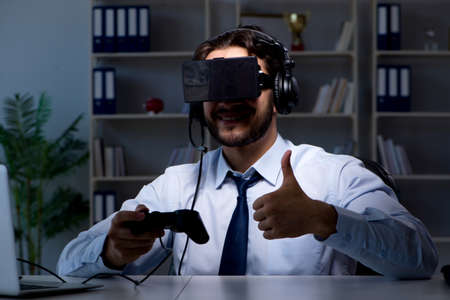 Businessman gamer staying late to play games