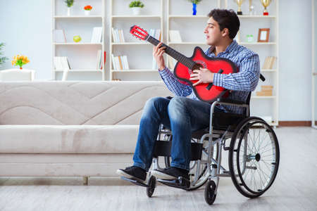 Disabled man playing guitar at homeの写真素材