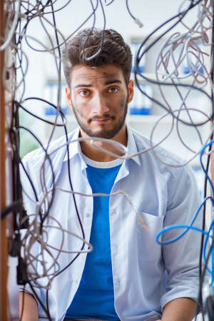 Electrician trying to untangle wires in repair conceptの写真素材
