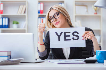 Young businesswoman with message in the officeの写真素材
