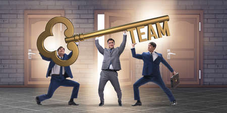 Businessmen holding giant key in team conceptの写真素材