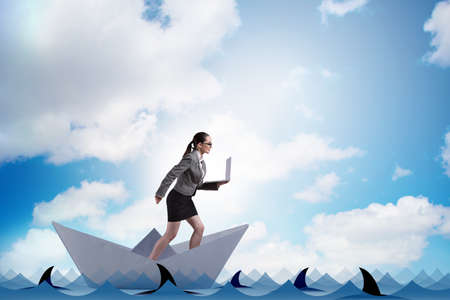 Businesswoman riding paper boat ship in business conceptの写真素材