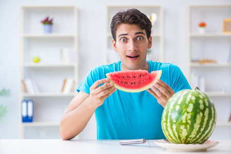 Man eating watermelon at homeの写真素材