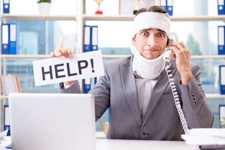 Injured businessman working in the officeの写真素材