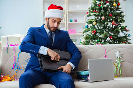 Businessman working at home during christmasの写真素材