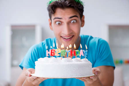 Young man celebrating birthday alone at homeの写真素材