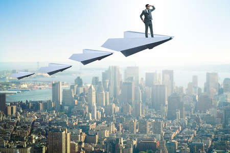 Businessman flying on paper plane in business conceptの写真素材