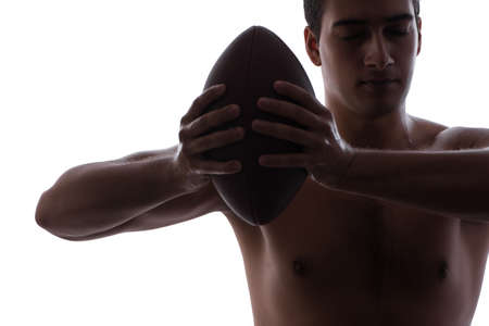 Ripped young man with american football isolated on whiteの写真素材