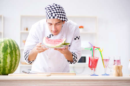 Male cook with watermelon in kitchenの写真素材