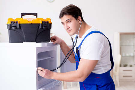 Repairman contractor repairing fridge in DIY conceptの写真素材