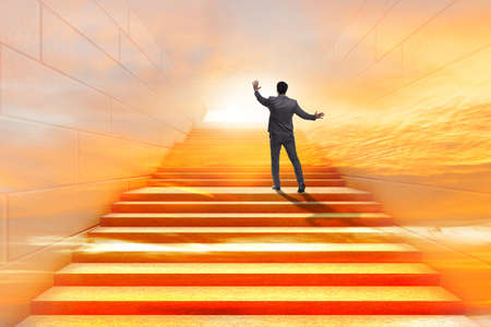 Businessman climbing up challenging career ladder in business coの写真素材