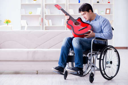 Disabled man playing guitar at homeの写真素材