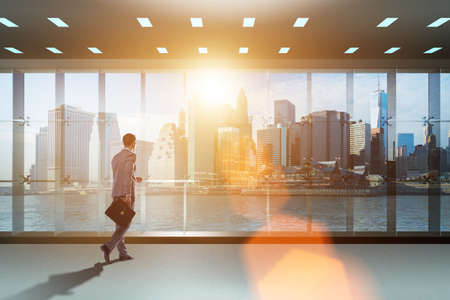 Businessman in front of office window thinking of new challengesの写真素材