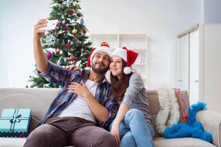 Young pair taking selfies during christmasの写真素材