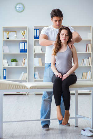 Young doctor chiropractor massaging female patient womanの写真素材