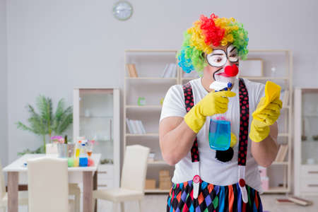 Funny clown doing cleaning at homeの写真素材