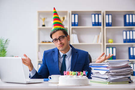Man celebrating birthday in the officeの写真素材