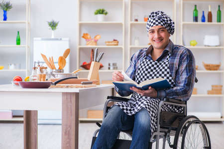 Young man cook with book of food recipesの写真素材