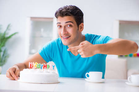 Young man celebrating birthday alone at homeの写真素材