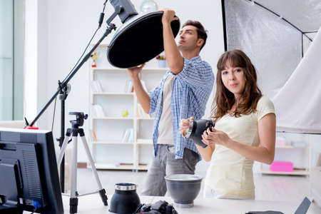 Young photographer working in photo studioの写真素材