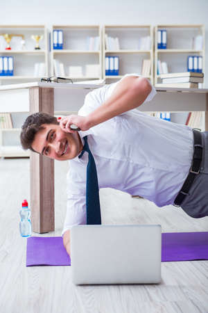 Businessman doing sports at his office spaceの写真素材