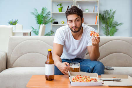 Man eating pizza having a takeaway at home relaxing restingの写真素材
