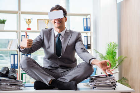 Businessman with VR virtual reality glasses in officeの写真素材