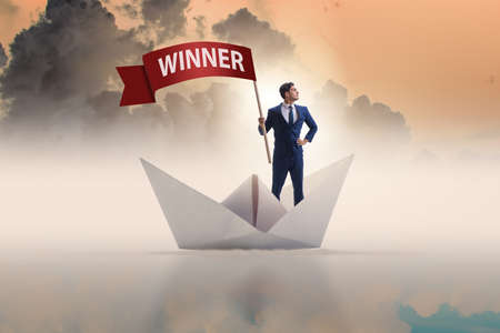 Businessman riding paper boat ship in winning conceptの写真素材