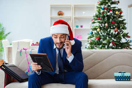 Businessman working at home during christmasの写真素材