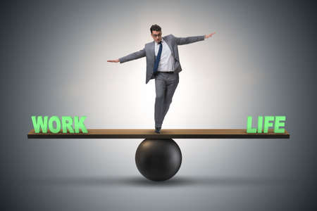 Businessman balancing between work and life in business conceptの写真素材