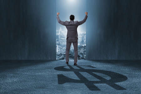Businessman casting dollar shape shadow in business conceptの写真素材