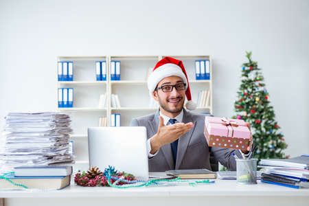 Young businessman celebrating christmas in the officeの写真素材