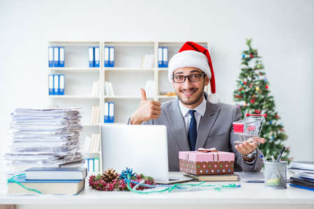 Young businessman celebrating christmas in the officeの写真素材