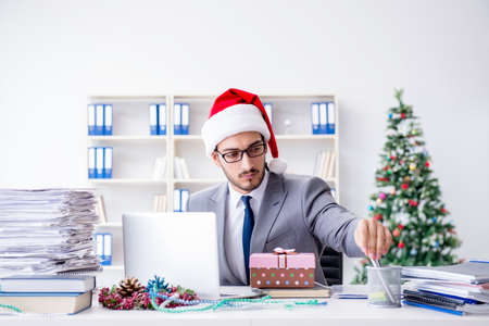 Young businessman celebrating christmas in the officeの写真素材