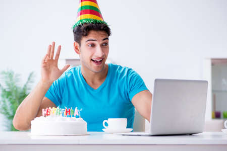 Young man celebrating birthday alone at homeの写真素材