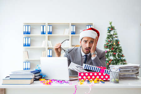 Young businessman celebrating christmas in the officeの写真素材