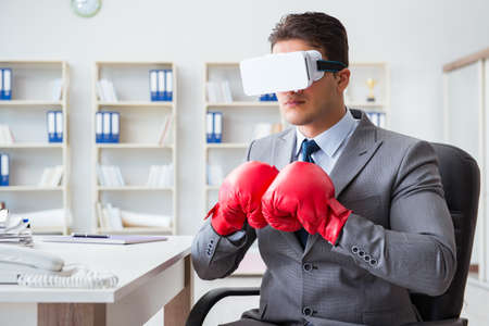 Man boxing in the office with virtual reality gogglesの写真素材