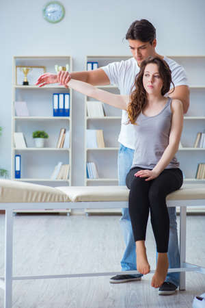 Young doctor chiropractor massaging female patient womanの写真素材