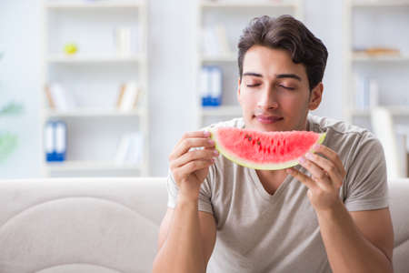 Man eating watermelon at homeの写真素材